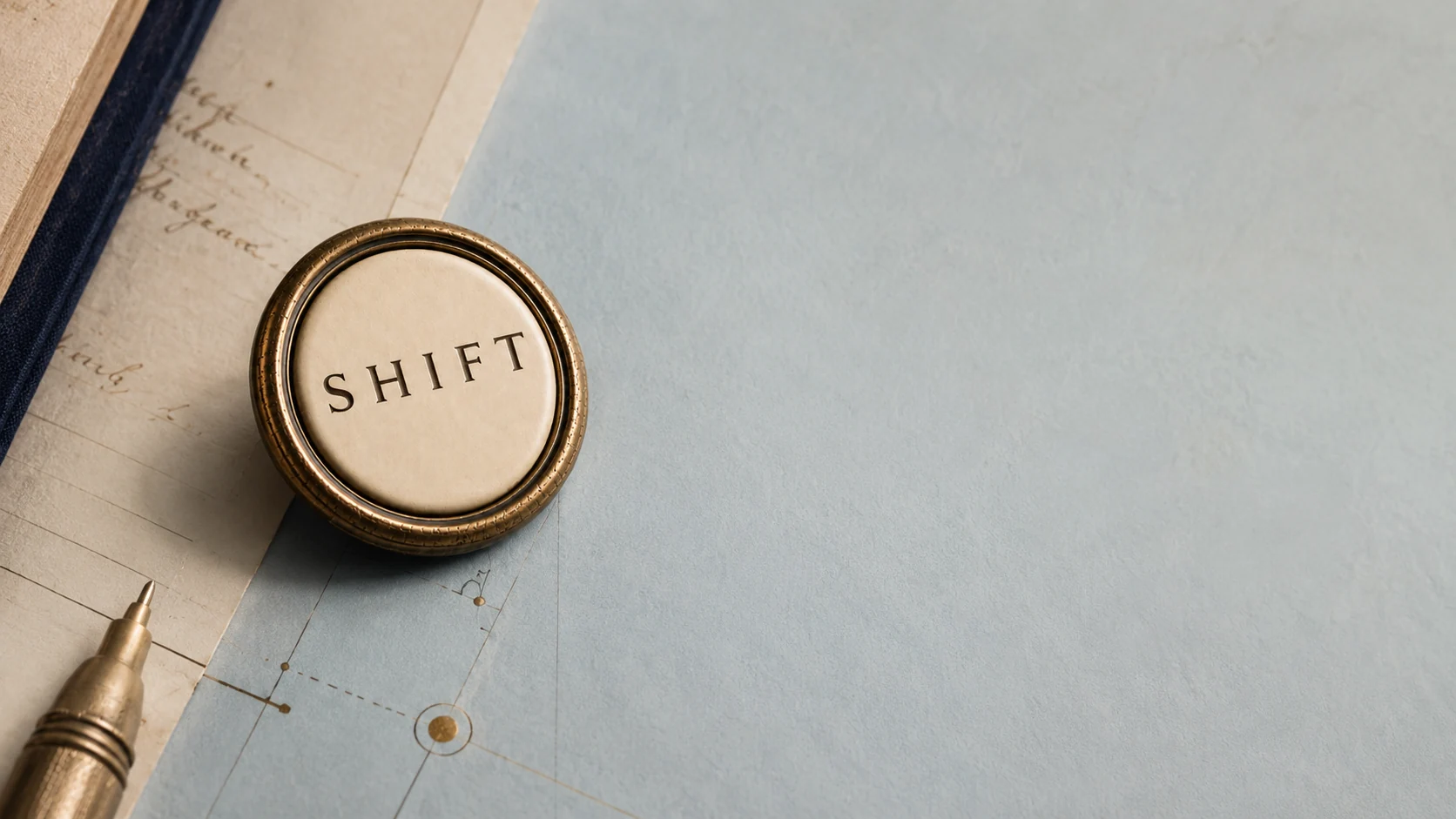 An antique brass SHIFT key arranged with cream paper, Parisian Sky blue, and brass drafting details